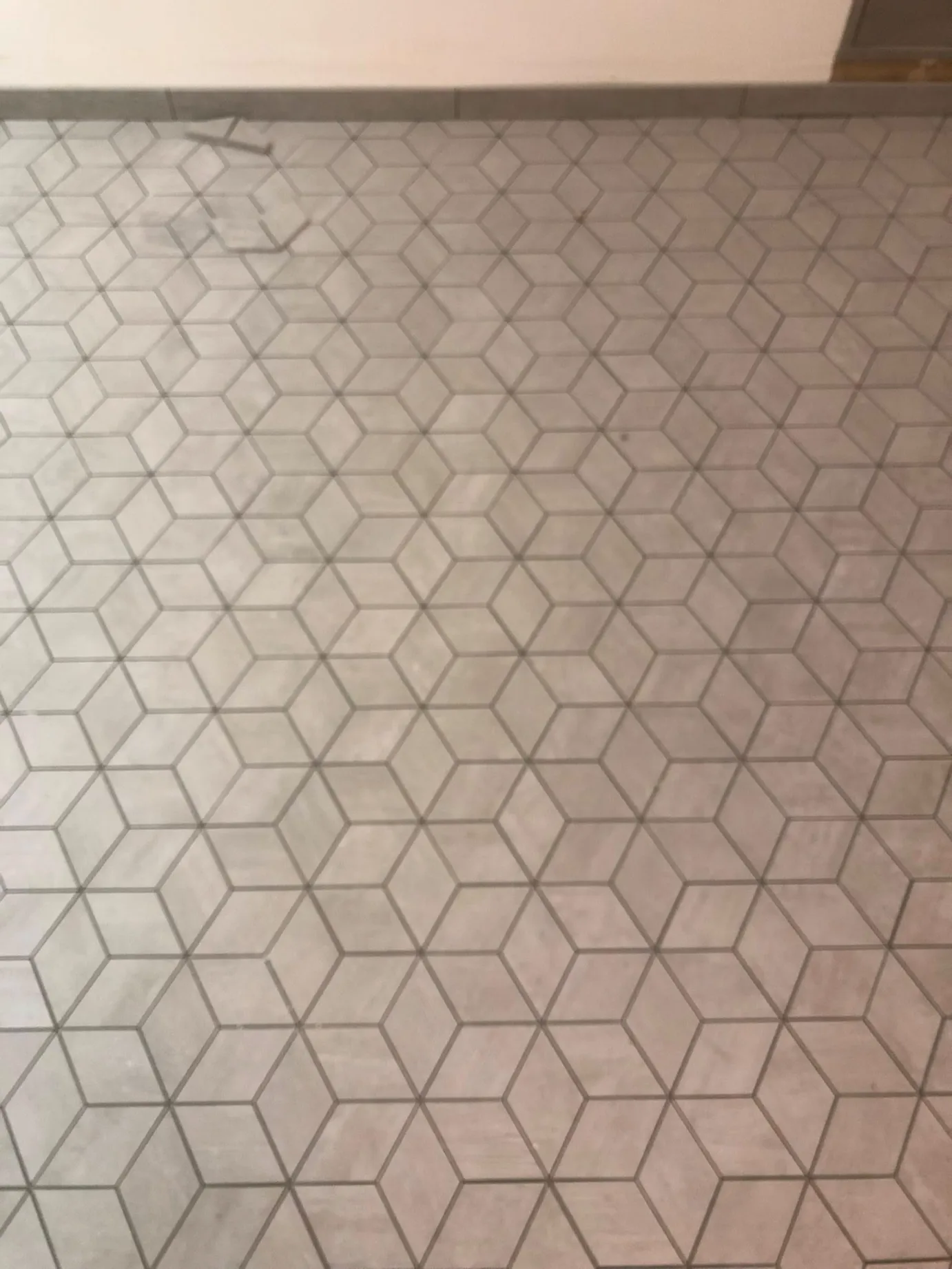 Geometric 3D cube pattern mosaic floor tile installation with gray tile baseboard trim by DMtilellc in Stamford CT