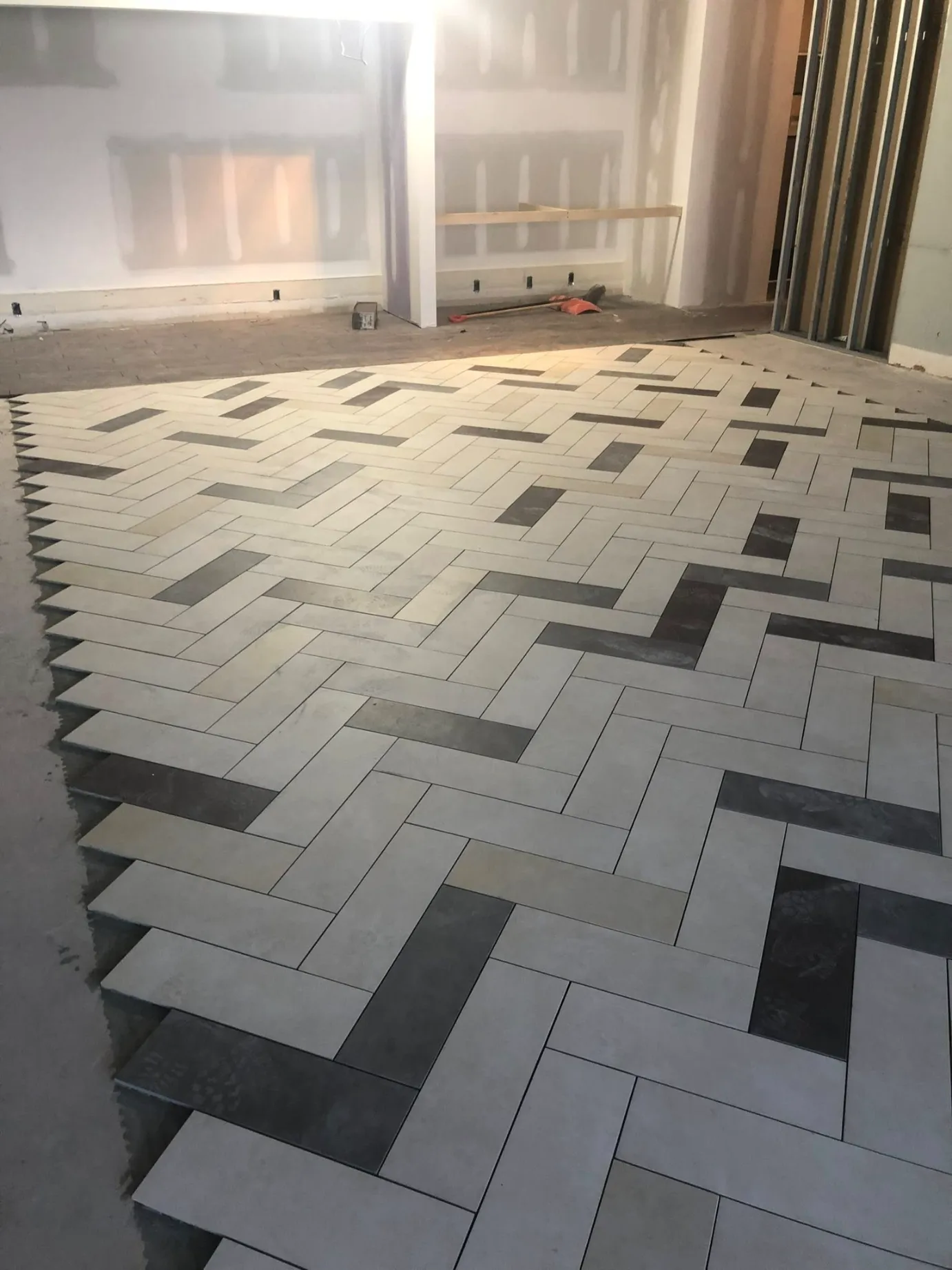 Interlocking white cross pattern mosaic tile backsplash with blue grout lines and LED strip lighting by DMtilellc in Westport CT